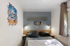 A bedroom with a bed, two pillows, a wall-mounted shelf, and a wall decoration.
