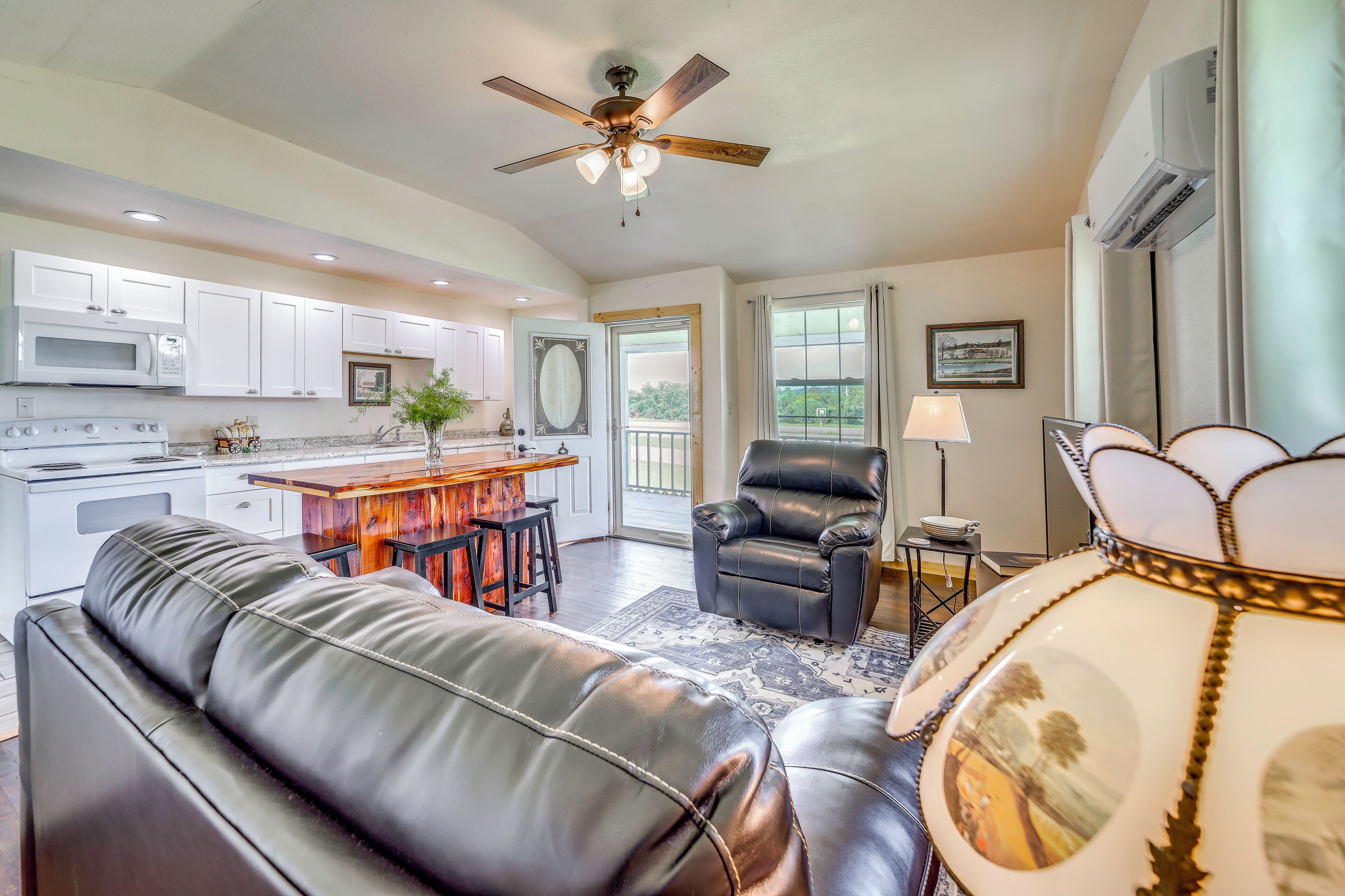 A modern kitchen with white cabinets, a built-in microwave, and a stove.