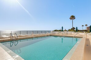 A clear blue pool with a 6 FT depth limit sign, surrounded by lounge chairs and a palm tree. - Dream Daytona Getaway: Beachfront Condo! (Daytona Beach)