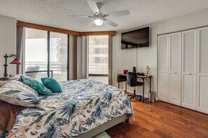 Ein Schlafzimmer mit Bett, Schreibtisch, Stuhl, Fernseher und Kleiderschrank.