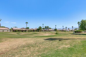 A residential area with houses, a grassy field, and palm trees. - Indian Palms Retreat Across From Empire Polo Club (Indio)
