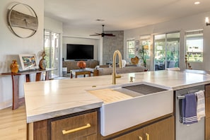 A modern kitchen with a central island, built-in appliances, and a large window providing natural light. - Indian Palms Retreat Across From Empire Polo Club (Indio)