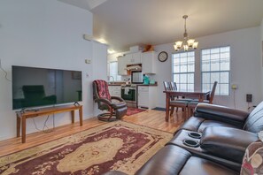 A living room with a flat-screen TV, leather sofa, and a dining area with a table and chairs. - Complimentary Golf Cart! Viewpoint Resort Home (Mesa)
