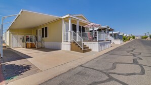A residential building with a covered porch, a staircase, and a driveway. - Complimentary Golf Cart! Viewpoint Resort Home (Mesa)