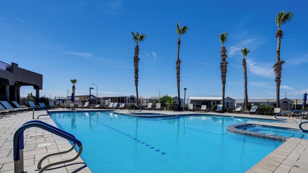 A swimming pool with palm trees, lounge chairs, and a clear blue sky. - Complimentary Golf Cart! Viewpoint Resort Home (Mesa)