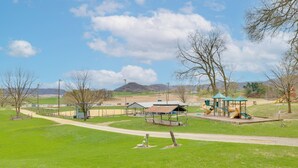 Un parque con juegos infantiles, mesas de picnic y una zona de estar techada.