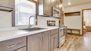 Una cocina moderna con armarios de madera, electrodomésticos de acero inoxidable y un amplio ventanal.