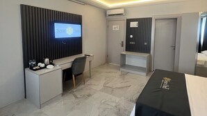 A modern hotel room with a flat-screen TV, a desk with a chair, a bed, and a wardrobe. - SESSE OTEL (Istanbul)