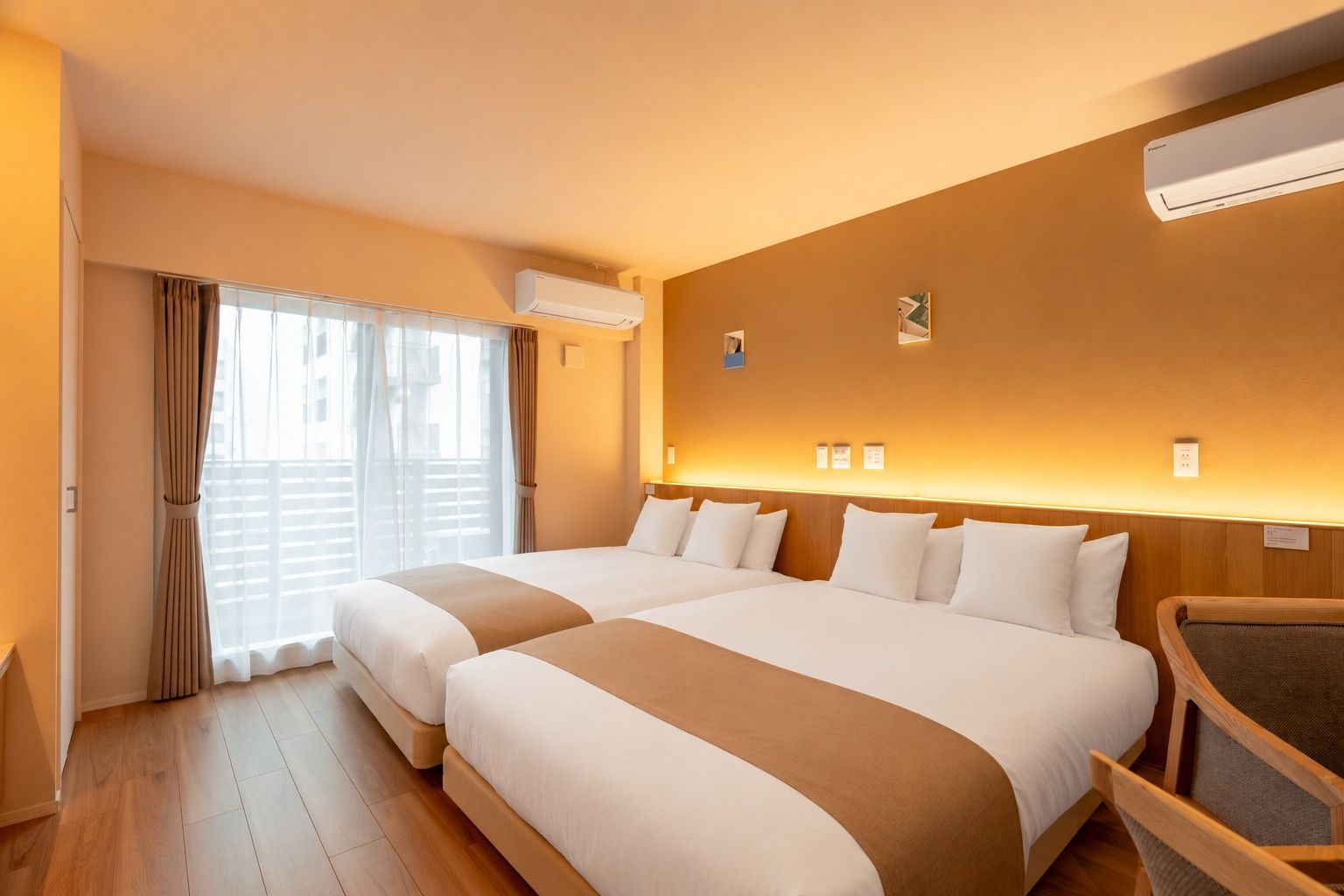 A hotel room with two beds, a wooden floor, an air conditioning unit, and a view of the outside.