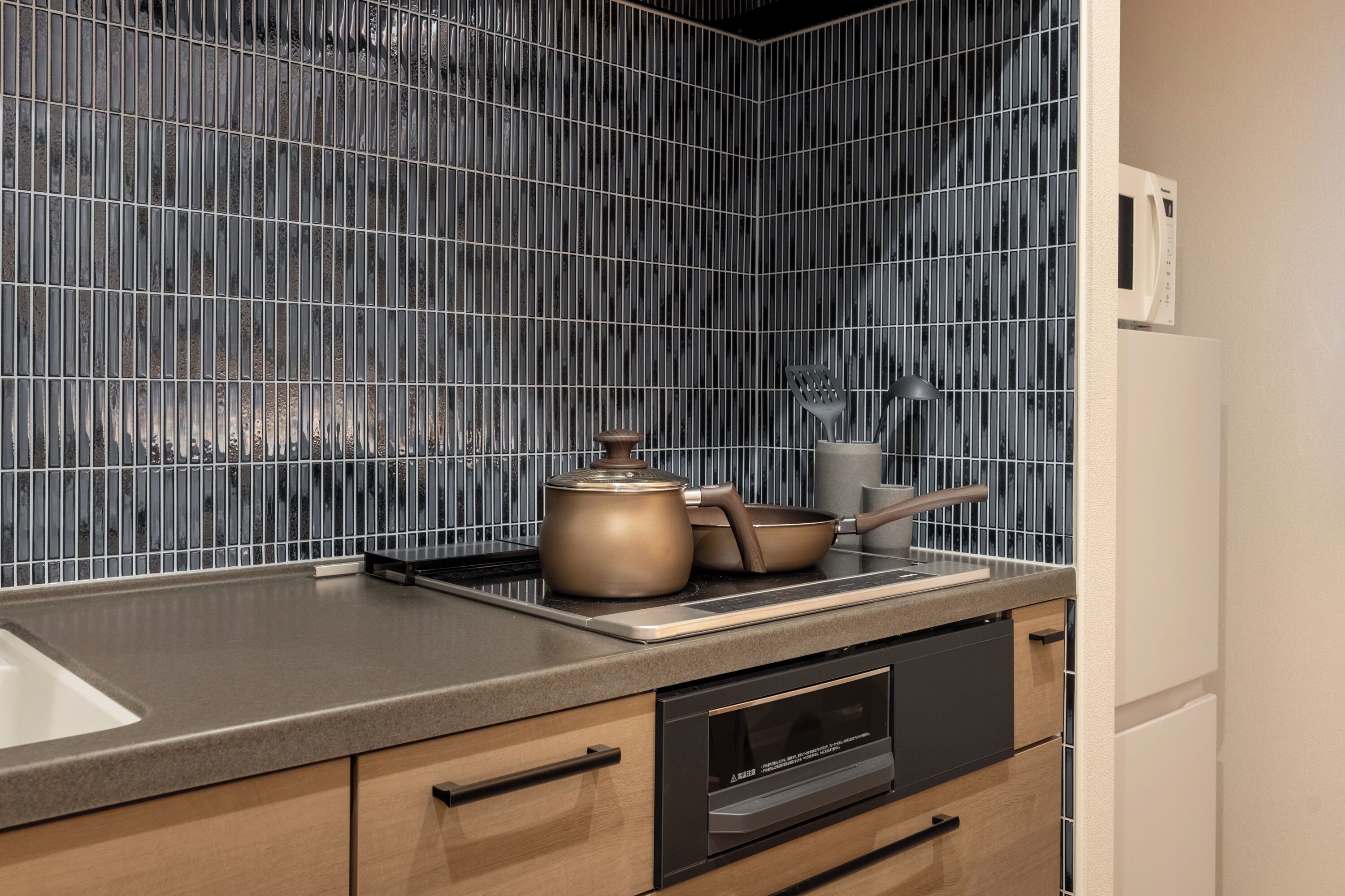 Una cocina moderna con campana extractora de acero inoxidable, microondas y horno empotrado.