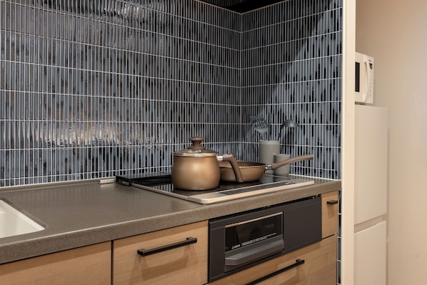 Una cocina moderna con campana extractora de acero inoxidable, microondas y horno empotrado.