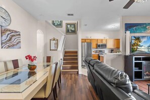 A modern kitchen with wooden cabinets, a refrigerator, and a microwave. - Spacious 4/3 Townhome in Regal Palms Resort (Davenport)