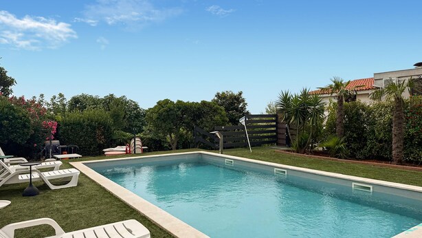 A rectangular swimming pool with a surrounding grassy area and lounge chairs. - 1 bedroom stunning apartment in Pula (Pula)