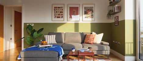 A modern living room with a grey sofa, a patterned rug, and a coffee table.