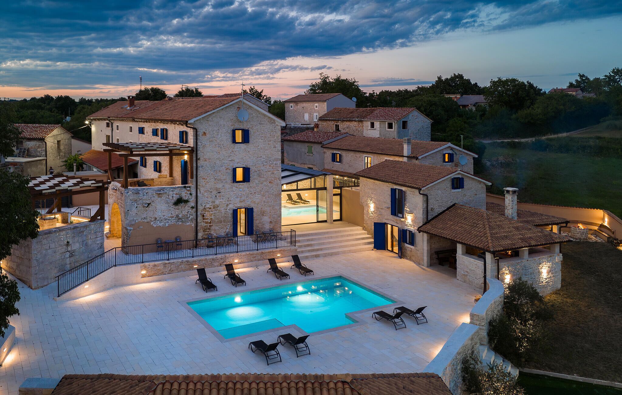 Une villa en pierre dotée d’une piscine, d’un espace extérieur aménagé et offrant une vue sur le paysage environnant.