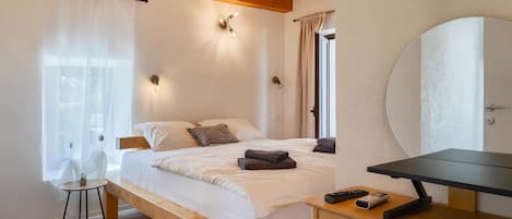 Un dormitorio con cama de madera, mesita de noche y espejo.