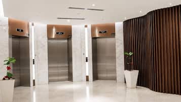A modern elevator area with three elevators, each marked with a lift number.