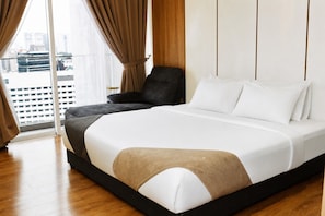 A modern hotel room with a large bed, a chair, and a view of the city through a large window. - Quill Residences KLCC by Moonlight (Kuala Lumpur)
