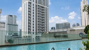 A swimming pool with a cityscape in the background. - Quill Residences KLCC by Moonlight (Kuala Lumpur)