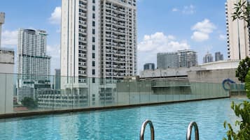 A swimming pool with a cityscape in the background.