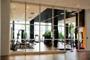 A modern gym with exercise equipment, large windows, and a clean, organized layout. - Quill Residences KLCC by Moonlight (Kuala Lumpur)