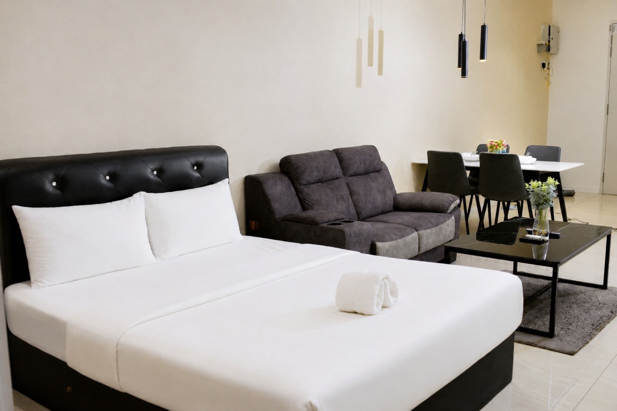 Una habitación de hotel con una cama, un sofá, una mesita y una silla.