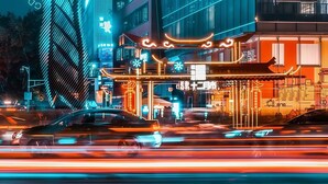 Un edificio moderno con facciata in vetro e insegna al neon.
