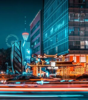 A modern building with a glass facade and a neon sign. - Chengdu Ben Hotel (Chengdu)