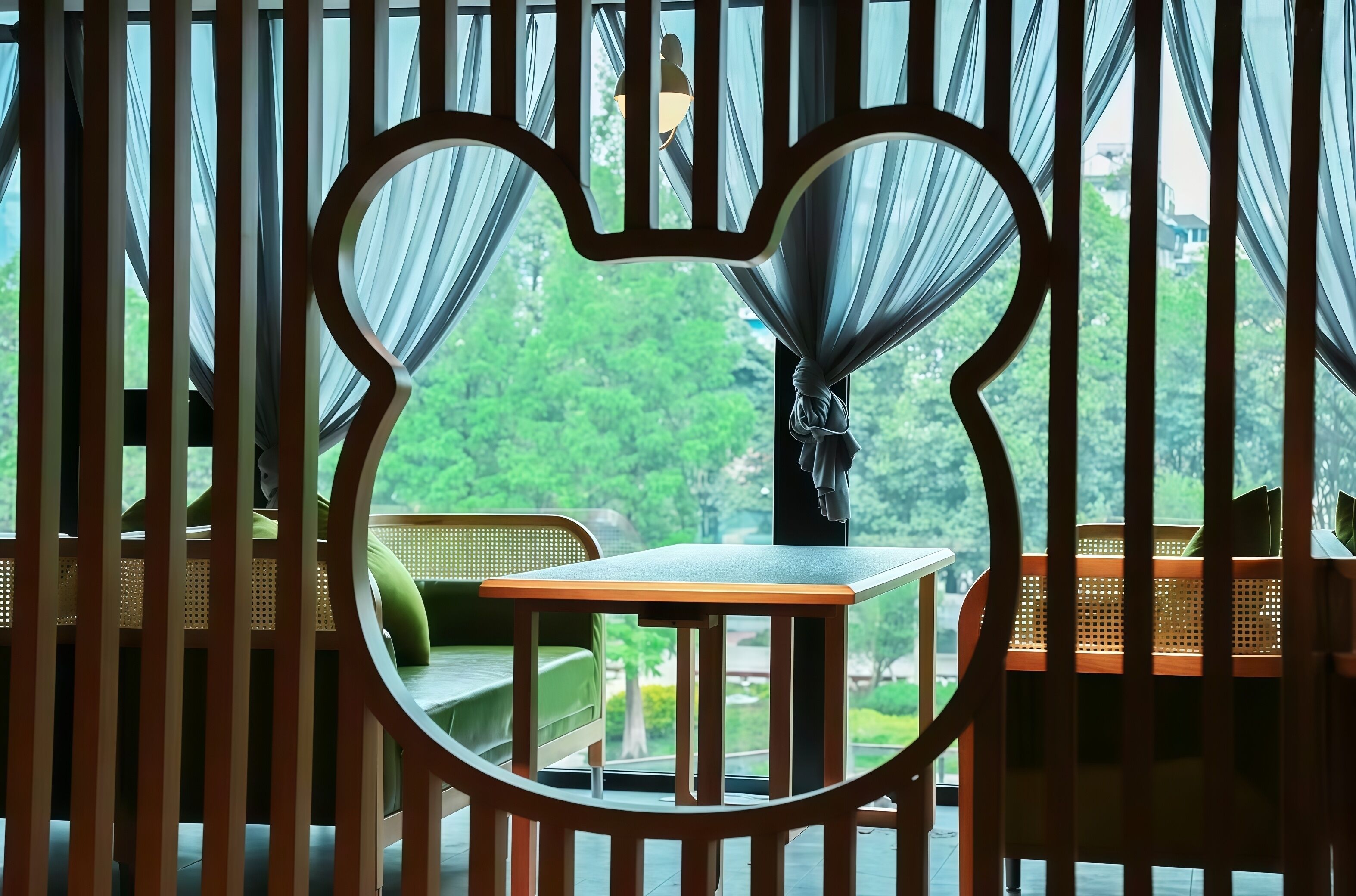 Una habitación con un marco de ventana en forma de corazón, una mesa y sillas.