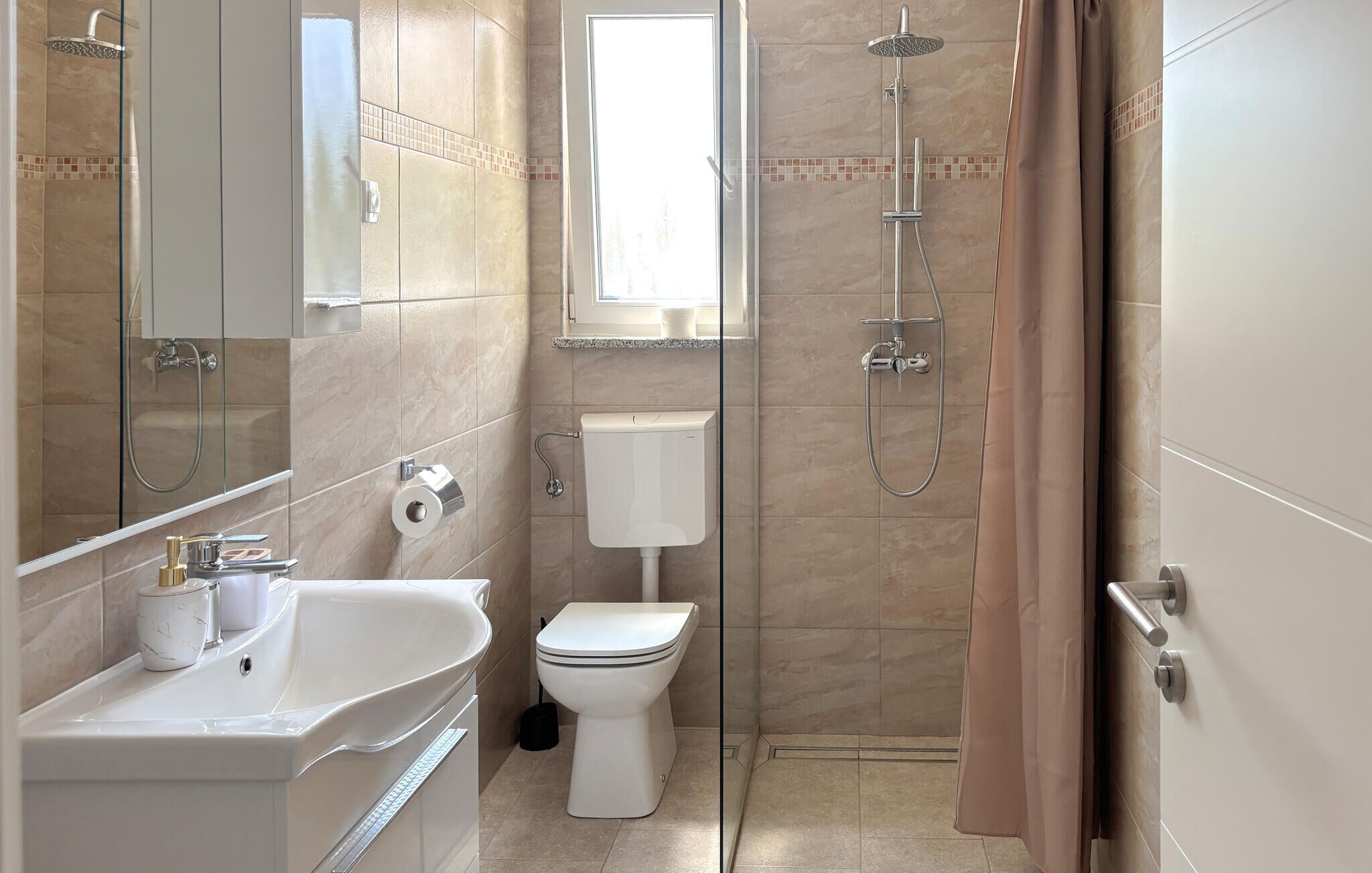 Een moderne badkamer met een bad, toilet en douche.