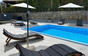 A swimming pool with lounge chairs and umbrellas. - Lovely apartment in Opric with swimming pool (Opric)