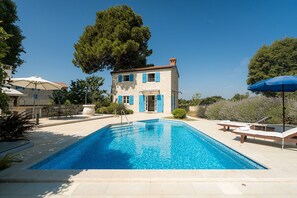 A pool area with a stone building, outdoor seating, and a large tree. - Villa Pajari (100581-K1) - Sveti Lovrec (Sveti Lovrec)