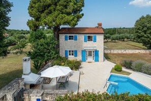 A two-story stone house with blue shutters, a swimming pool, and a patio with outdoor furniture. - Villa Pajari (100581-K1) - Sveti Lovrec (Sveti Lovrec)