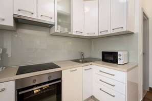 A kitchen with white cabinets, a built-in oven, a microwave, and a stainless steel sink. - Villa Pajari (100581-K1) - Sveti Lovrec (Sveti Lovrec)