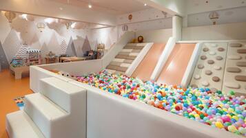 A children's play area with a ball pit, slides, and climbing structures.