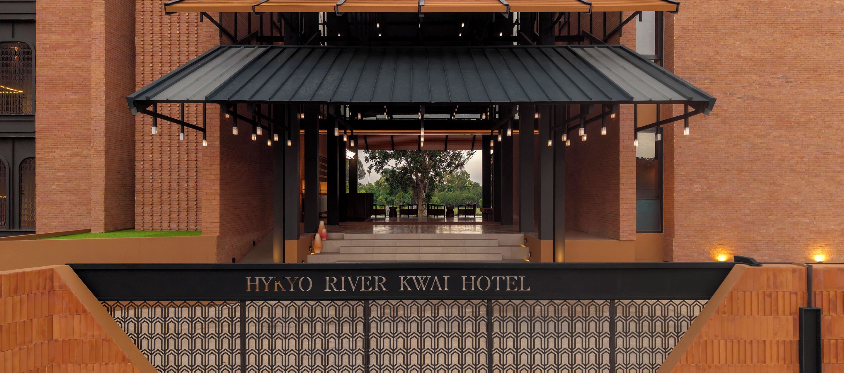 L’entrée de l’hôtel Hykyo River Kwai, avec une galerie couverte menant à l’entrée principale.