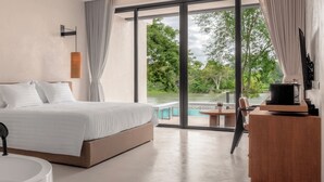 A modern bedroom with a large bed, a bathtub, and a view of a lake. - Hykyo River Kwai Hotel (Kanchanaburi)