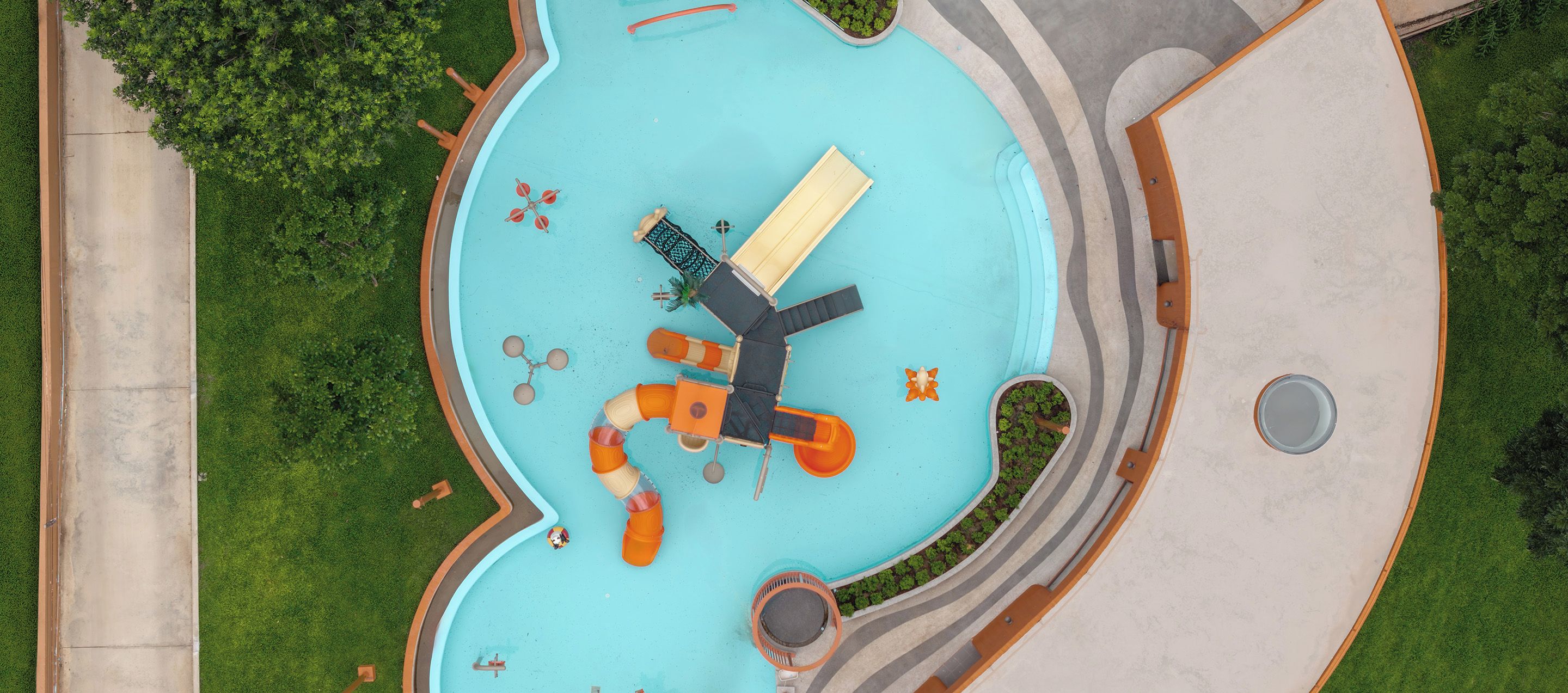 A top-down view of a swimming pool with a windmill, a slide, and a small boat.