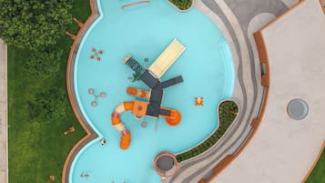 A top-down view of a swimming pool with a windmill, a slide, and a small boat.