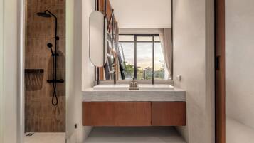 A modern bathroom with a shower, a large mirror, and a window.