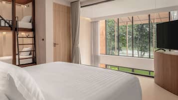 Ein modernes Schlafzimmer mit Bett, Fernseher, einem Holzschrank und einem Fenster mit Blick auf Grünflächen.