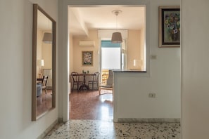 A hallway with a dining area, a mirror, and a painting on the wall. - Casa Lelia – A special view in the heart of Cagliari 🌅✨ (Cagliari)