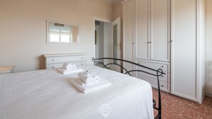 Et soveværelse med seng, garderobeskab og spejl.
