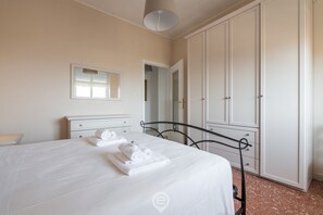 Ein Schlafzimmer mit einem Bett, einem Kleiderschrank und einem Spiegel.