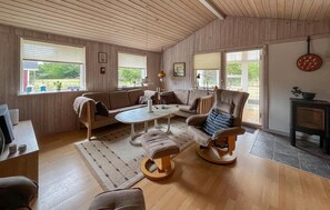 A cozy living room with a sofa, armchairs, a coffee table, and a fireplace. - Lovely home in Storvorde with WiFi (Storvorde)