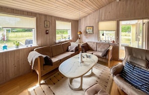 A cozy room with a wooden interior, a sofa set, a table, and large windows with blinds. - Lovely home in Storvorde with WiFi (Storvorde)