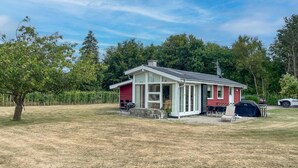 Et etplanshus med en overdækket veranda, grill og parabolantenne.