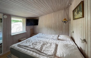 A bedroom with a bed, a television mounted on the wall, and a window with blinds. - Lovely home in Storvorde with WiFi (Storvorde)