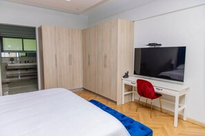A bedroom with a bed, a TV, a desk with a chair, and a wardrobe. - Apartment in siavonga (Siavonga)