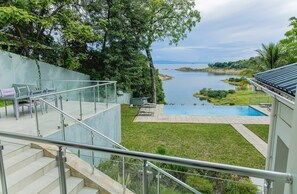 A modern outdoor area with a pool, stairs, and a view of a lake.